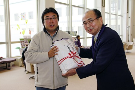 伊藤所長から景品を受け取る千葉孝紀さん（左）