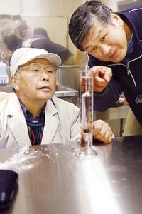 発酵させた米のアルコール度数を測定する佐藤静雄さん（左）と工業技術センターの中山繁喜上席専門研究員