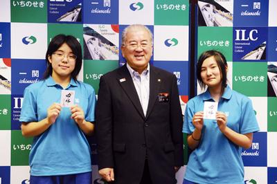 勝部市長（中）から手渡された「必ず勝つべ」のメッセージカードを手に、健闘を誓う三石副部長（左）と佐藤部長