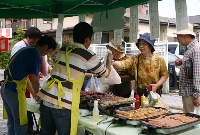 会話を楽しみながら熱々の品を求める来場者