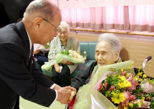 浅井市長（左）の祝福ににっこりと応えるナツコさん