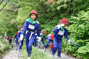 山頂付近の沿道で清掃活動を行う子どもたち