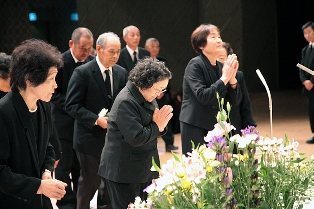 戦没者の冥福を祈り手を合わせる参列者