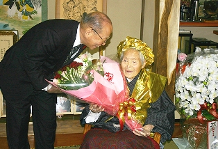 祝福の花束に笑顔で応じるう志さん（右）