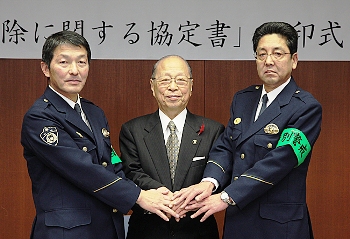 協定書に調印後、固く握手。左から吉田一関警察署長、浅井市長、板垣千厩警察署長