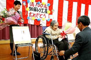 親族から贈られた花束に笑顔で応じる加藤トシヱさん