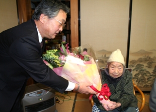 花束を笑顔で受け取る小野寺ミツキさん（右）