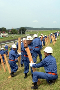 「籠止め工法」のくい打ちを行う水防隊員