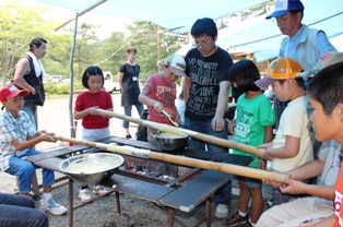 両市の小学生らが協力してバームクーヘン作りに挑戦しました