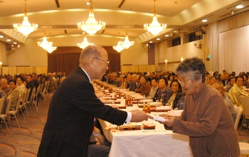 9月12日行われた山目地区敬老会で、浅井市長（左）から記念品を受け取る早川昭子さん