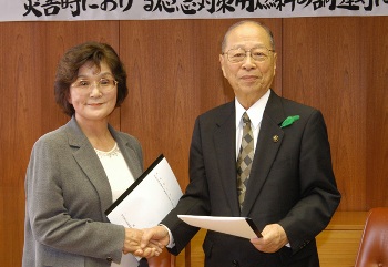 協定書に調印後、固く握手を交わす浅井市長（右）と熊谷支部長