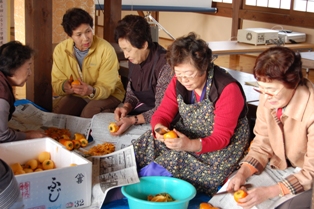 ふるさとの味の出来上がりを楽しみに柿の皮をむいた参加者