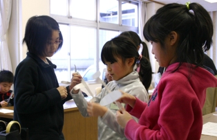 うまく作れたかなと紙ヒコーキの出来栄えを見せ合う子供たち