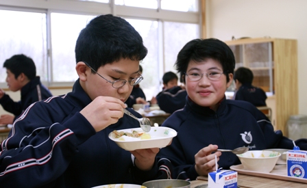 最初のメニューは、みんなが大好きなカレー。会話もにぎやかに「おいしーい」(一関東中１年の教室で)