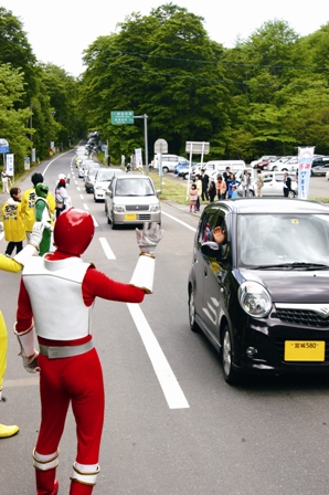  11.正午に真湯ゲートが開くと、待ちわびていた多くの車が須川を目指しました。ご当地ヒーロー・ゲイビマンと勇壮な太鼓演奏が通行者の安全を祈りました