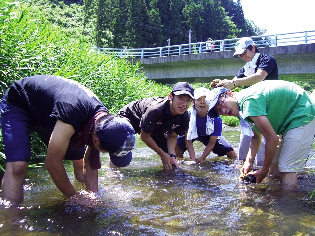 特製の古縄たわしを使って、川底の石を丁寧に磨きました