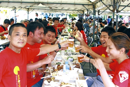 この日のために作った揃いの赤いＴシャツを着て乾杯