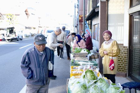 毎回新鮮な野菜などが並ぶ七日市で品定めをする買い物客