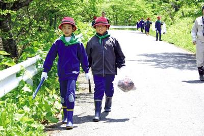 沿道に捨てられたごみを拾いながら歩く子どもたち