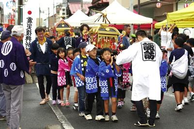 元気にみこしをかつぐ子供たち