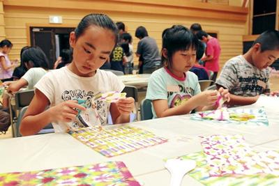 染色した東山和紙を好きな形に切る子供たち