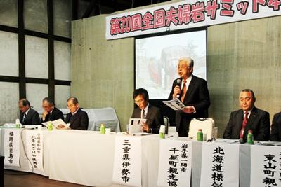 夫婦岩サミット本会議の様子。千厩町観光協会小野寺維久郎副会長が夫婦石（めおといわ）のいわれなどを説明した