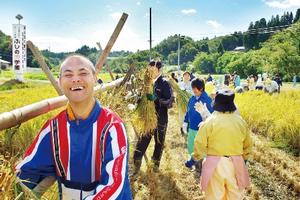 約200人が参加したふじの実学園の稲刈り。利用者も慣れた手つきで手刈りした