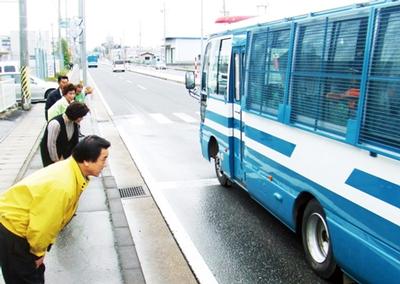 被災地に向かう警察関係車両にあいさつする千田社長と内藤印刷社員