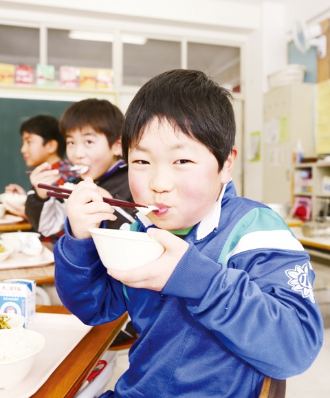 おいしそうに雑煮もちを食べる本寺小の小岩弥也君