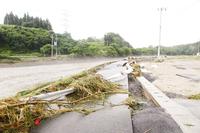 濁流によってぐにゃりと曲がったガードレールと損壊した道路（大東町摺沢地内）