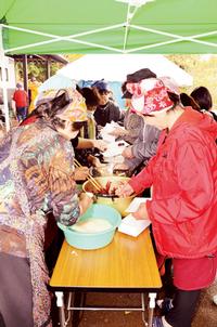 つきたての餅を愛情込めて調理する本寺地区地域づくり推進協議会会員の皆さん