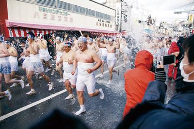 沿道から一斉に清め水を浴びる