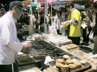 香ばしいにおいが漂う手焼きせんべいの実演にお客さんが寄ってきます