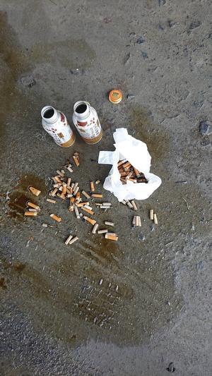 ポイ捨てされた吸い殻と灰皿の写真