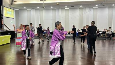 交流30周年記念フェスティバルで参加者とくるくる踊りを踊る様子