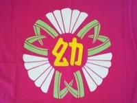 赤荻幼稚園の園章。赤地に緑の荻の葉と白い花があしらわれ、金色の「幼」の文字が中央に配置されている。