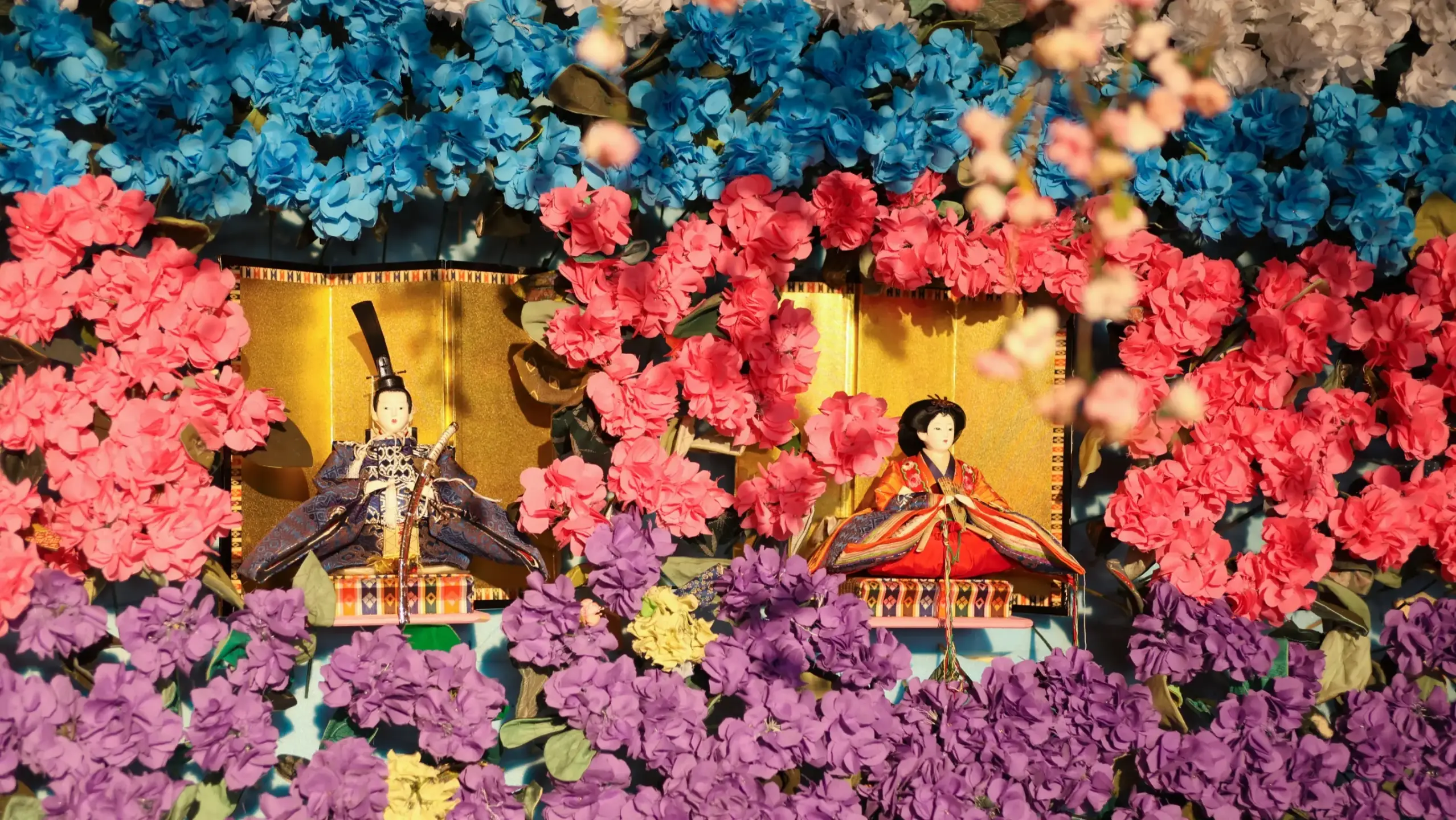 雛人形が花に囲まれているせんまやひなまつりの写真